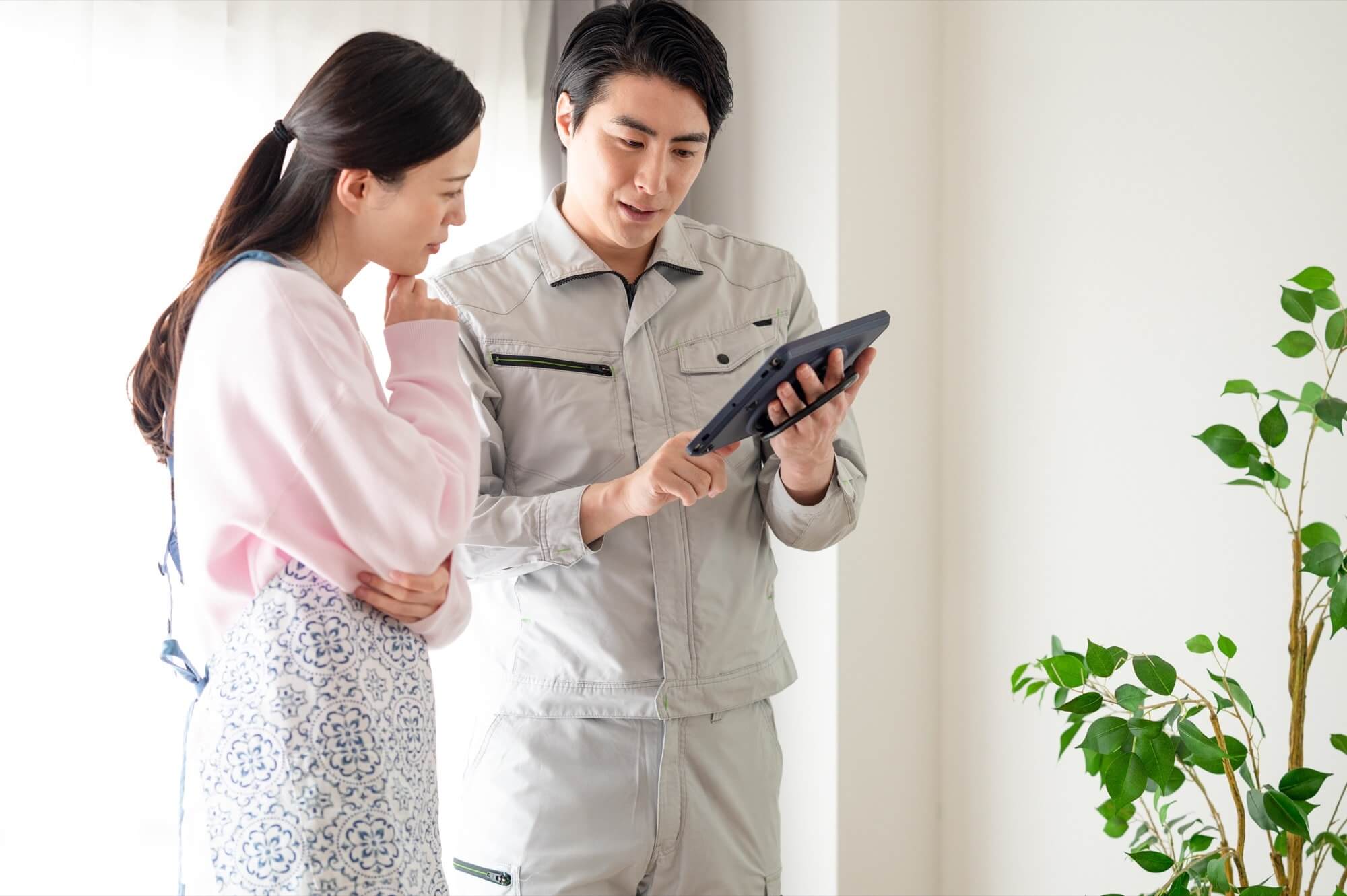 作業員からリフォームの見積もり説明を受ける主婦