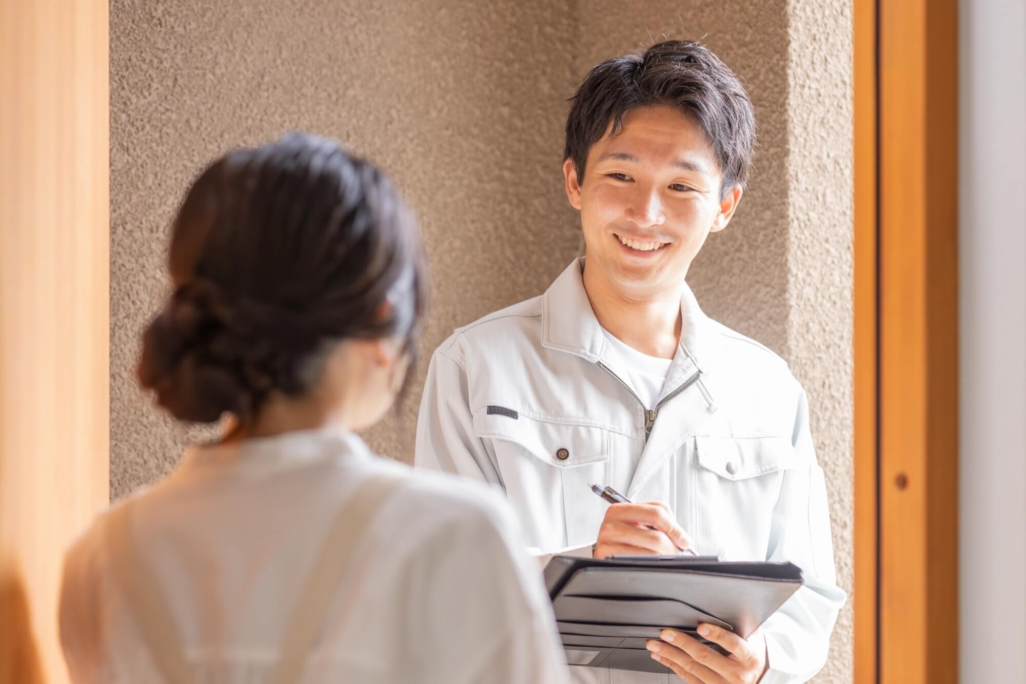 作業着姿のリフォームスタッフと話を聞く主婦